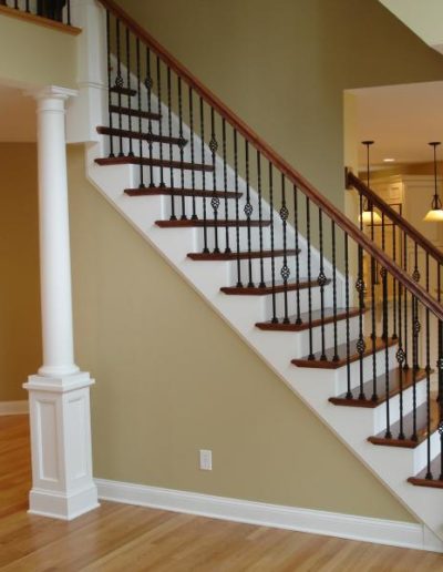 staircase in a new construction home featuring wooden treads and iron spindles