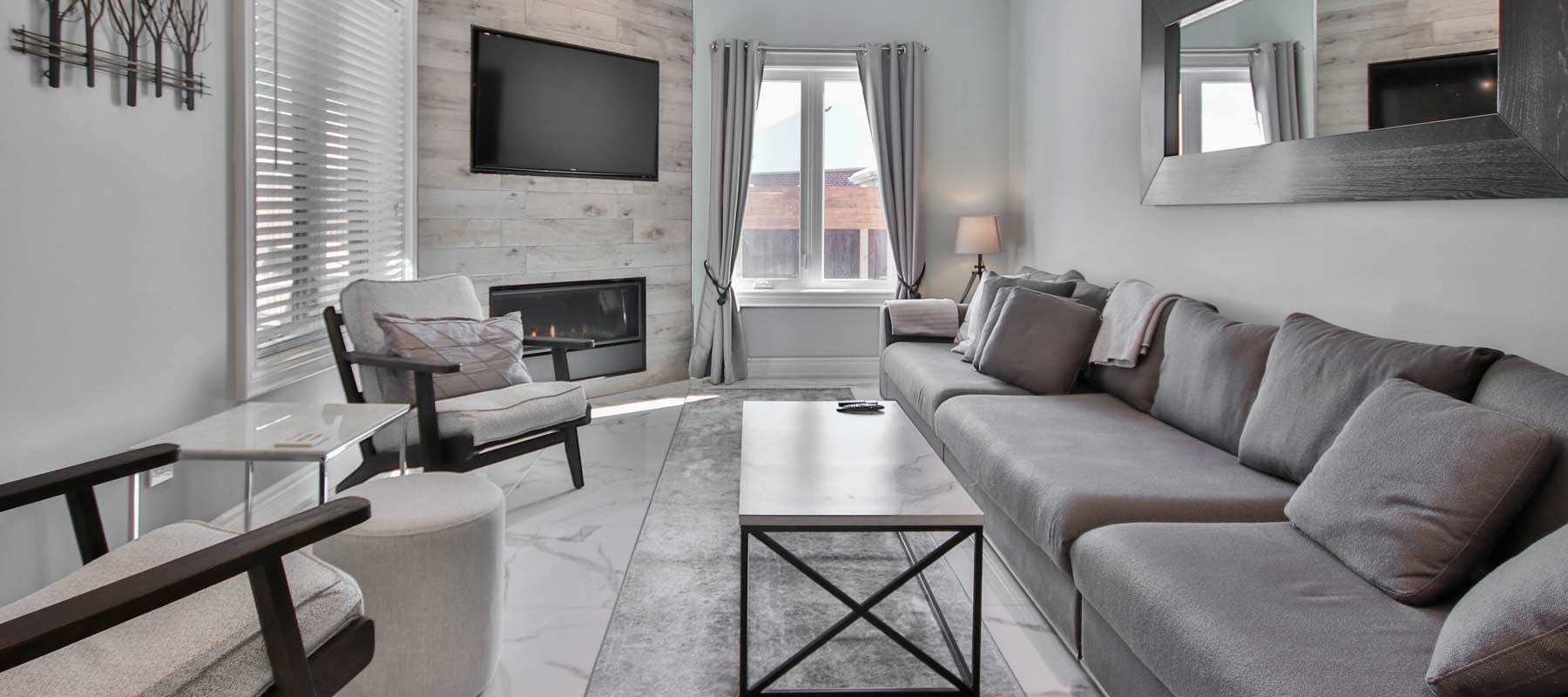 gray living room with a fireplace and tv