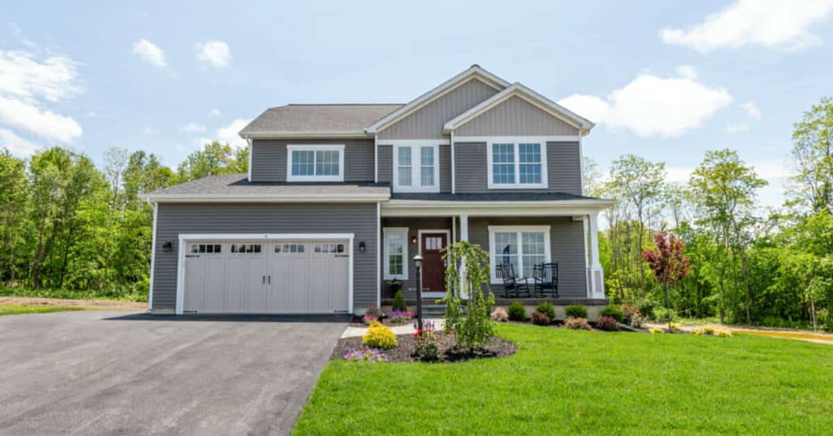 outside of a house with a grassy lawn and one large garage door